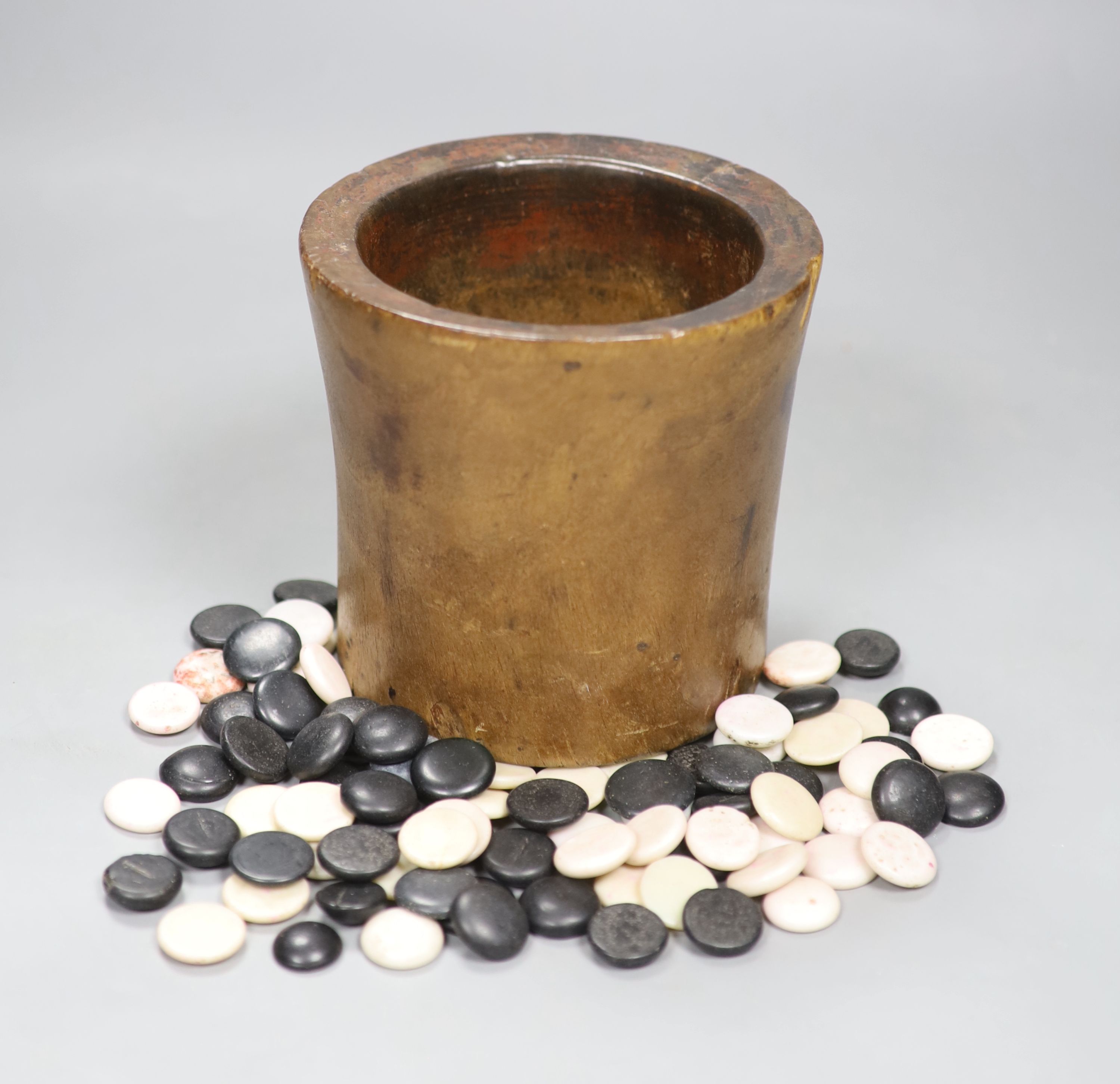 A collection of stone weiqi counters, Ming-Qing dynasty, contained in a nanmu brushpot